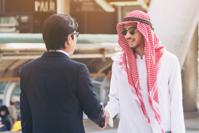 Chinese and Arabic man shaking hands